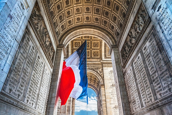 Arc de Triomphe French Flag Paris France. Completed in 1836 monument to the dead in the French Revolution and Napoleonic Wars. Includes tomb to unknown soldier